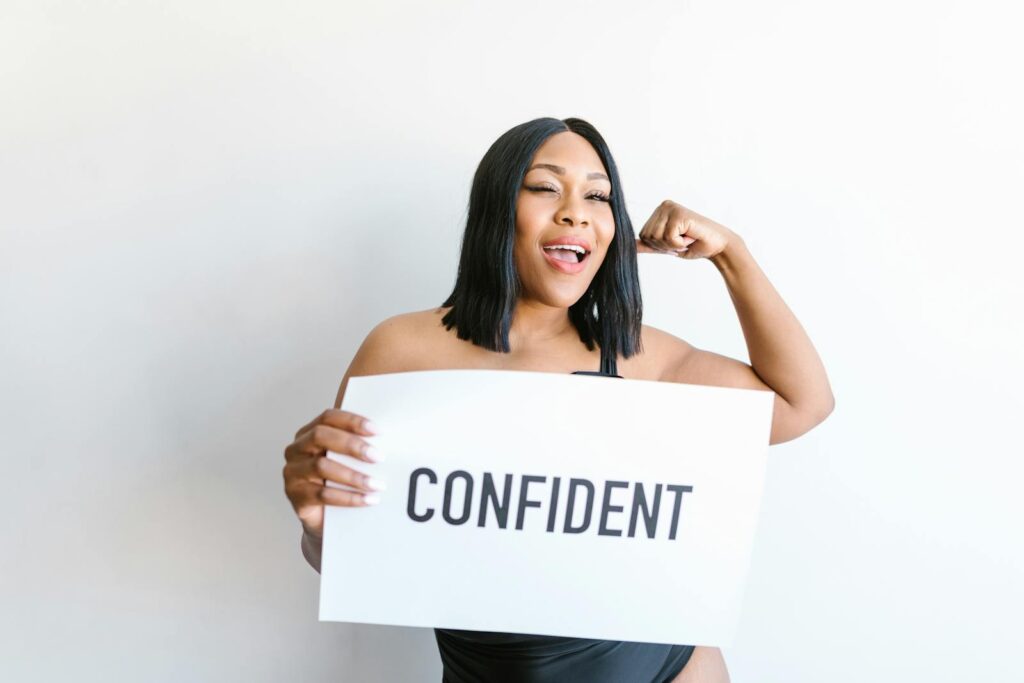 Portrait of a confident plus-size woman holding a sign promoting body positivity and self-love.