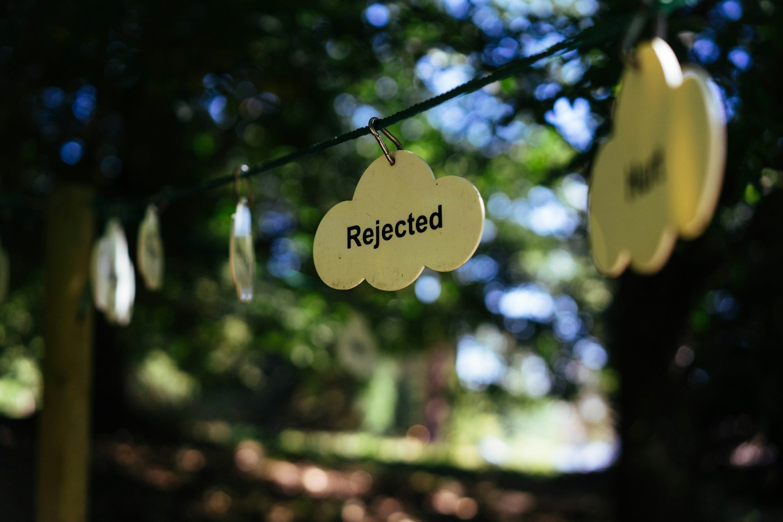 Signs reading "rejected" hang on a line.