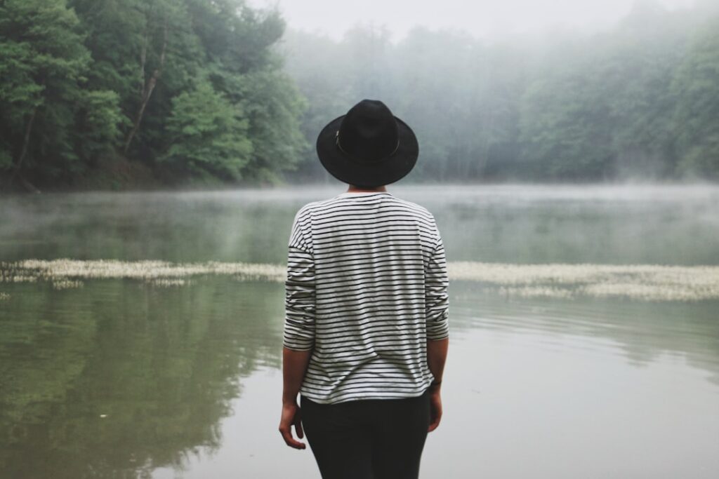 person standing near swamp lake during daytime