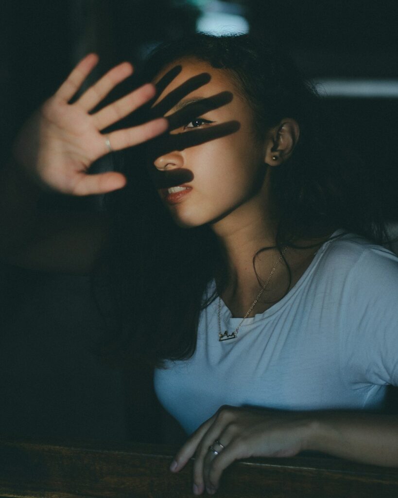 woman wearing white scoop-neck shirt inside dark room