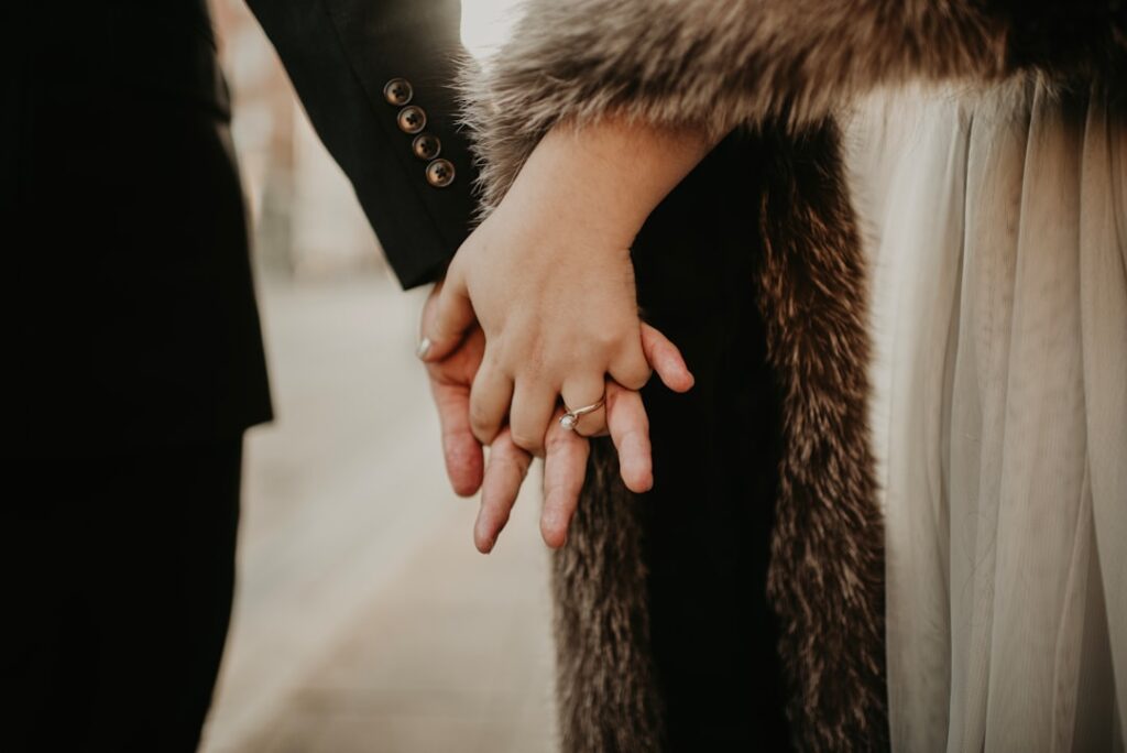 person in black coat holding hand